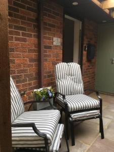 two chairs sitting next to a brick wall at St Marks Court Holiday Homes - No1 in Marske-by-the-Sea