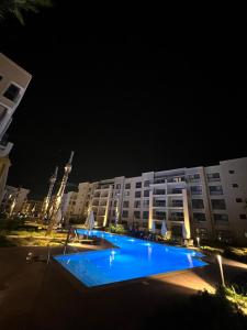 a large building with a blue pool at night at Elegant 1BR Chalet at Marassi Marina 2 in El Alamein
