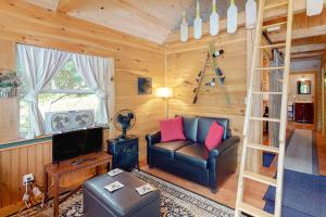 a living room with a couch and a television in a cabin at Loon Cove in Waterville