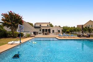 a swimming pool with chairs in front of a house at Town of Ocean View --- 30680 Cedar Neck Rd in Ocean View