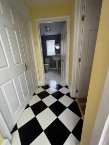 un corridoio con pavimento a scacchi in bianco e nero di La Mignonne Aketoise a Peterborough