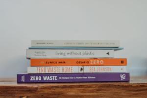 einen Stapel Bücher auf einem Tisch in der Unterkunft Villa Saudade - Sustainable Living in Porto Covo