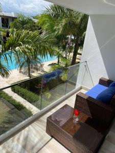 einen Balkon mit Blick auf den Pool und die Palmen in der Unterkunft Boca Paraiso in Boca Chica