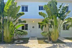 ein weißes Haus mit Palmen davor in der Unterkunft Boca Paraiso in Boca Chica