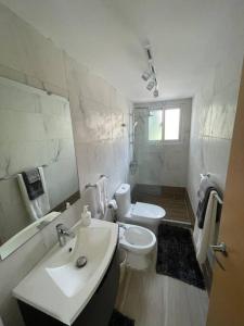 a white bathroom with a toilet and a sink at Boca Paraiso in Boca Chica