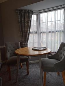 a living room with a table and two chairs and a window at Cherry Tree Cottage in Bempton