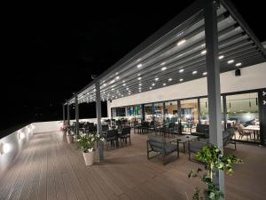 a deck with tables and chairs on a building at night at Hotel Boutique Aquarel in Zalău
