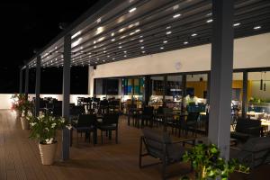 un restaurante con mesas y sillas en una terraza por la noche en Hotel Boutique Aquarel en Zalău