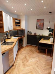 a kitchen with a sink and a table and a counter at Tórshavn City Apartment in Tórshavn