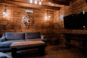 ein Wohnzimmer mit Sofa und Flachbildfernseher in der Unterkunft Black River in Kolašin