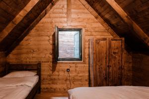 a bedroom with two beds in a wooden cabin at Black River in Kolašin