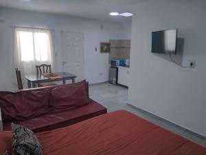 sala de estar con sofá, mesa y TV en Departamento 3 Complejo Sol de Oeste en San Juan