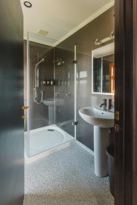 a bathroom with a shower and a sink at Misty Cove Homestead in Renwick