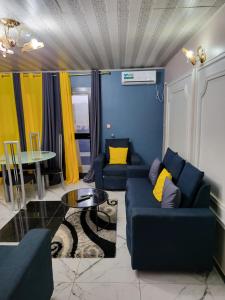 a living room with two blue couches and a table at Lux Résidence in Yaoundé