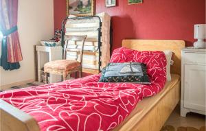 a bedroom with a bed with a red wall at Amazing Home In Yttery With Wifi in Ytteroy