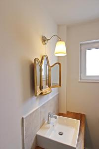 een badkamer met een witte wastafel en een lamp bij Villa Danica Murter in Betina