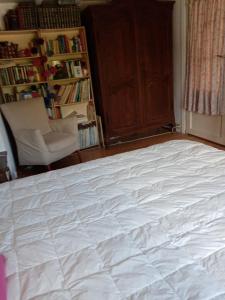 1 dormitorio con 1 cama blanca grande y 1 silla en Emcée B&B en Kapellen
