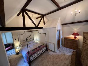 an attic bedroom with a bed and a dresser at Braunston Manor Cottage in Braunston