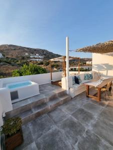 un patio con sofá, mesa y piscina en Ninemia Naxos Suites en Naxos