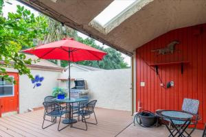 a patio with a table and chairs and an umbrella at Getaway to iki Tampa is an End Unit Townhome - Close to Tampa Bay & Downtown - Minutes to Airport in Tampa
