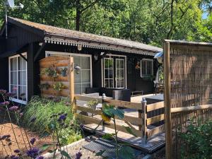 a black tiny house with a wooden fence at Chalet Harmony in Zutendaal