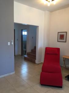 einen roten Stuhl im Wohnzimmer mit Treppe in der Unterkunft Jardin El Rompio Casa 35 in Los Santos