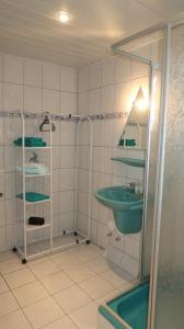 ein Badezimmer mit einem grünen Waschbecken und einer Dusche in der Unterkunft Ferienwohnung Walter - Friedrichroda in Friedrichroda
