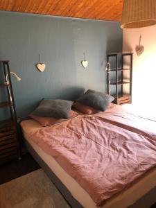 1 dormitorio con 1 cama con corazones en la pared en Chalet Happiness, en Zutendaal