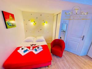 Habitación con cama roja y silla roja. en La petite Maison dans la Croix Rousse, en Lyon