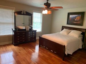 1 dormitorio con cama, tocador y espejo en Serene 6BR country home on 325 acres ATV for rent, en Burgettstown