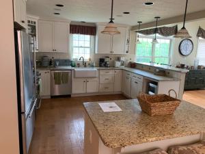 cocina con armarios blancos y encimera en Serene 6BR country home on 325 acres ATV for rent, en Burgettstown