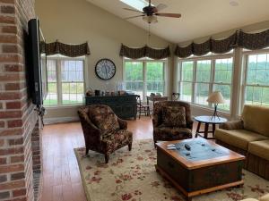 a living room with a couch and chairs and a table at Serene 6BR country home on 325 acres ATV for rent in Burgettstown