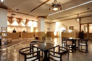 eine Lobby mit 2 Tischen und Stühlen und eine Cafeteria in der Unterkunft Hotel New Tsuruta in Beppu