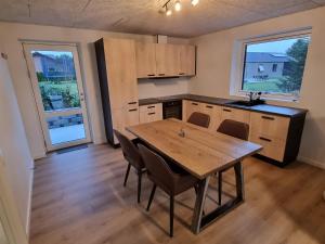 una cocina vacía con mesa de madera y sillas en Bonico, en Horsens