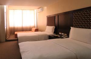Ένα ή περισσότερα κρεβάτια σε δωμάτιο στο Coron Gateway Hotel & Suites