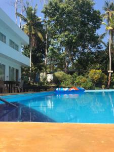 a large swimming pool in front of a house at Karma Guesthouse in Hikkaduwa