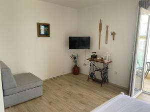 een woonkamer met een bank en een tafel met een tv bij Villa Danica Murter in Betina