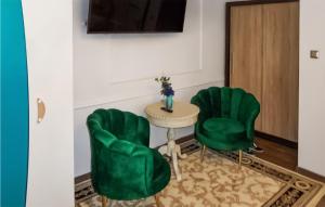 two green chairs and a table in a room at 1 Bedroom Nice Apartment In Kolobrzeg in Kołobrzeg