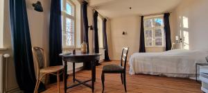 a bedroom with a bed and a table and chairs at Hug&Dim im Gasthaus am Finowkanal in Wandlitz
