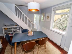 a dining room with a blue table and chairs at Lime Cottage in Matlock