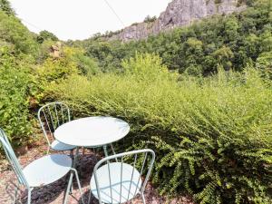 two chairs and a table with a view of a mountain at Lime Cottage in Matlock