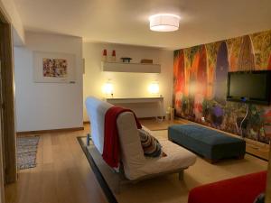 uma sala de estar com um sofá e uma televisão de ecrã plano em Casa de Férias com piscina - Condominio Vilamouraténis em Vilamoura