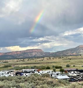 un arco iris en el cielo sobre un estacionamiento en The Riverside Ranch Motel and RV Park Southern Utah, en Hatch