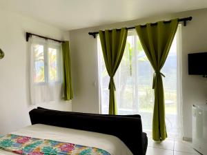 a bedroom with green curtains and a bed and a window at Rinconcito Verde in Ujarrás