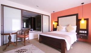 a bedroom with a bed and a desk and a chair at Coron Gateway Hotel & Suites in Coron