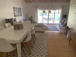 uma sala de estar com uma mesa branca e cadeiras em Casa de Férias com piscina - Condominio Vilamouraténis em Vilamoura