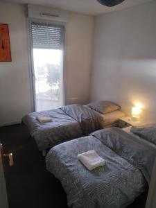 a room with three beds and a window at A Poitiers, 2 chambres, très bel appartement de 65 m2 in Poitiers