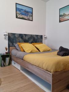 - une chambre avec un grand lit et des oreillers jaunes dans l'établissement Izicozy Studios - Immeuble Guillemot, à Châtellerault