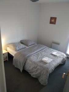 1 dormitorio con 1 cama con 2 toallas en A Poitiers, 2 chambres, très bel appartement de 65 m2, en Poitiers