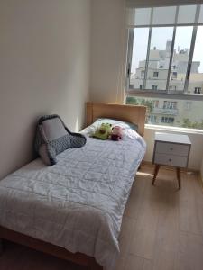 a bedroom with a bed with a stuffed animal on it at Departamento Full en Lince in Lima